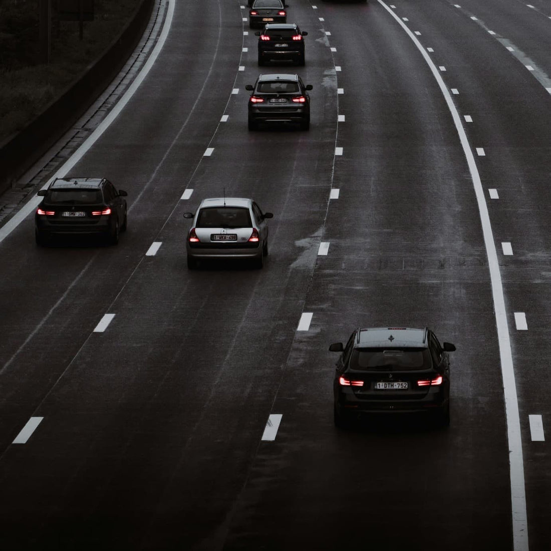 Widok ruchu na autostradzie z kilkoma samochodami jadącymi po mokrej nawierzchni.
