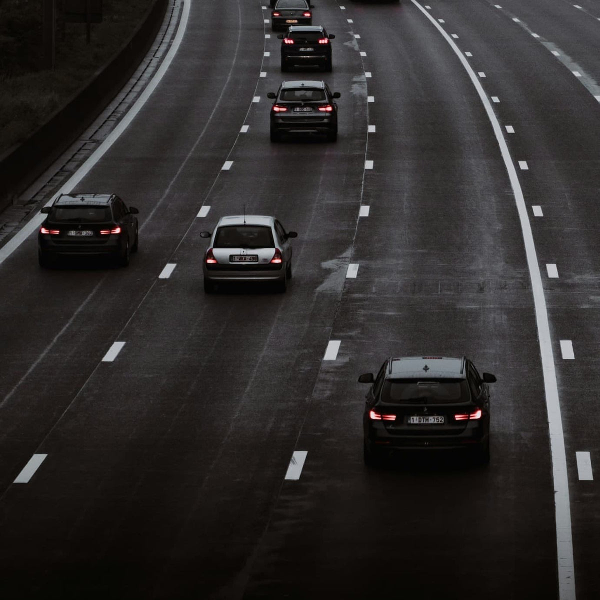 Widok ruchu na autostradzie z kilkoma samochodami jadącymi po mokrej nawierzchni.
