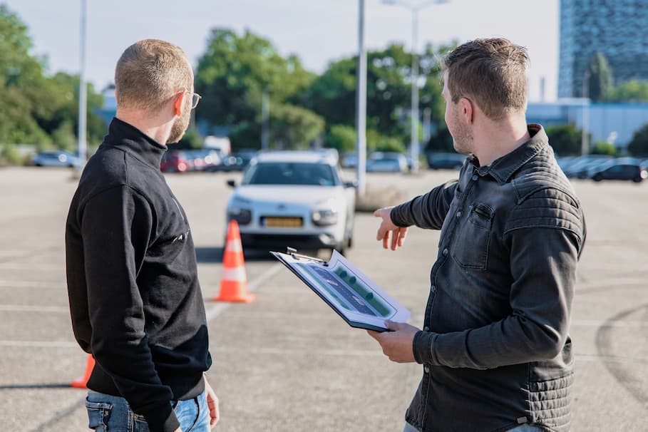 Instruktor udziela wskazówek podczas praktycznego egzaminu na prawo jazdy.