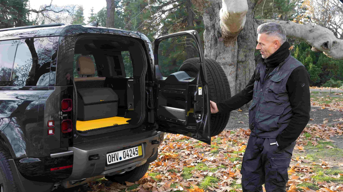 Mężczyzna otwiera bagażnik SUV-a z żółtą matą Prime EVA.